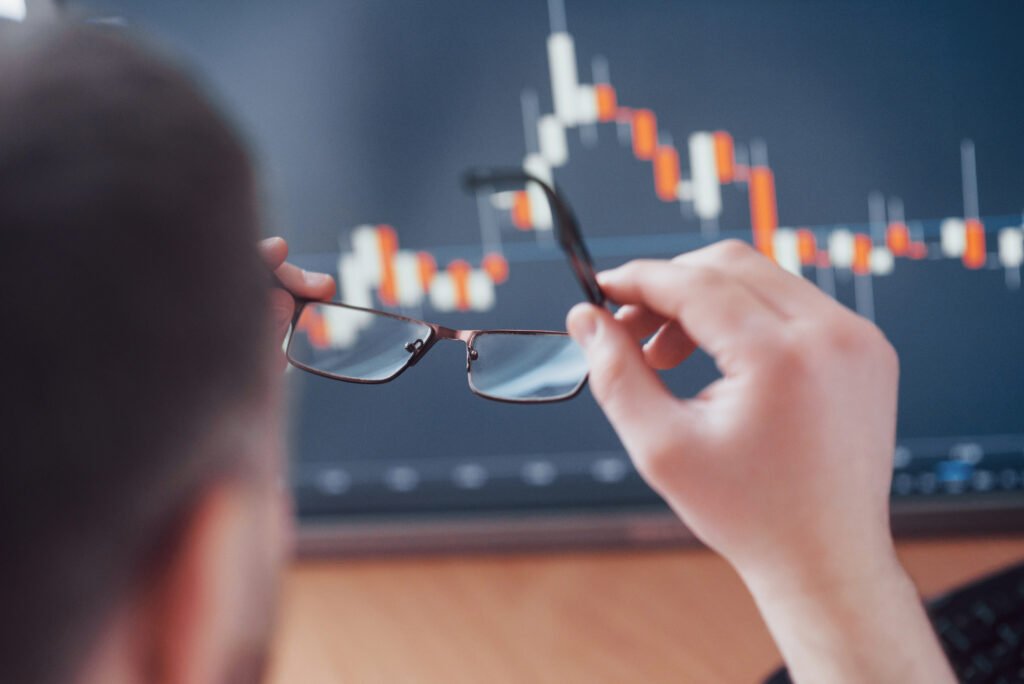 A Importância de Fazer Investimentos com Seu Dinheiro em 2025 2 analyzing data close up young businessman who holds glasses looks gff while working creative office 1